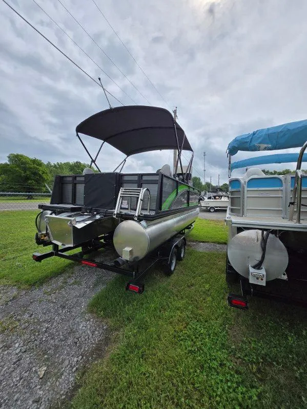 Slide: The Image of 2025 Qwest 20 XRE FISH pontoon boat with canopy, parked on grass. - 2