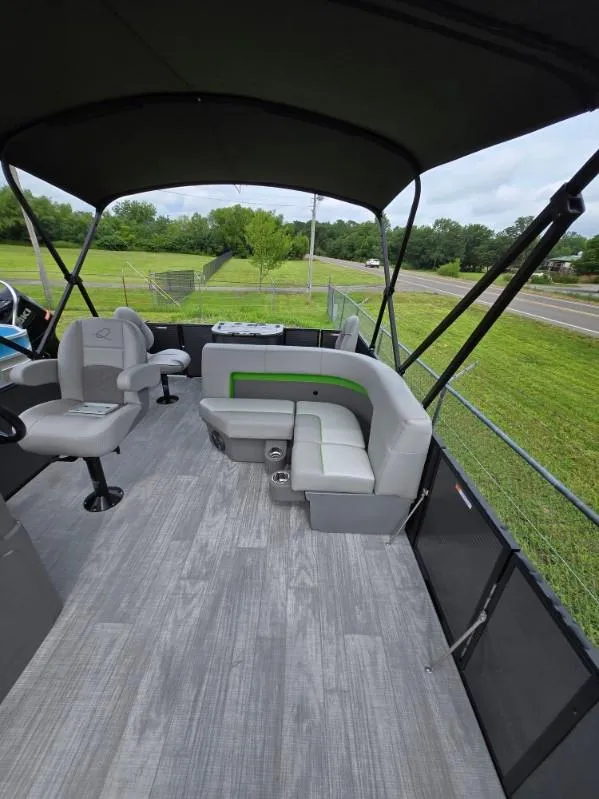 Slide: The Image of 2025 Qwest 20 XRE FISH boat interior with seating and canopy, on a grassy background. - 7
