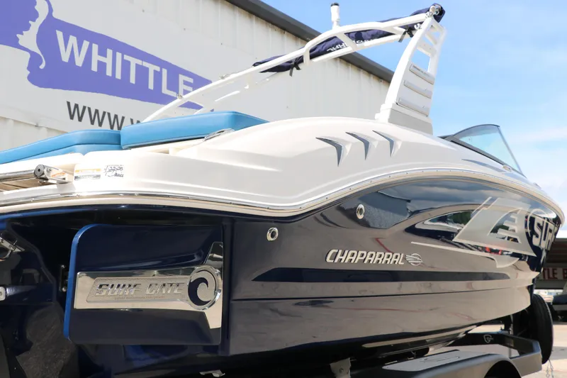 Slide: The Image of 2025 Chaparral 21 Surf boat, sleek design, blue and white color, displayed outdoors. - 8
