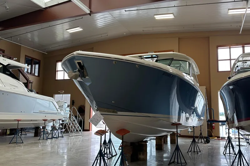 Slide: The Image of 2022 Tiara Yachts 38 LX in showroom, blue hull, elevated on stands. - 12