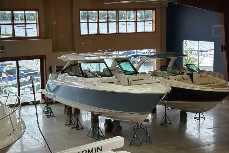 Slide: The Image of 2022 Tiara Yachts 38 LX displayed indoors with other boats, large windows in background. - 15