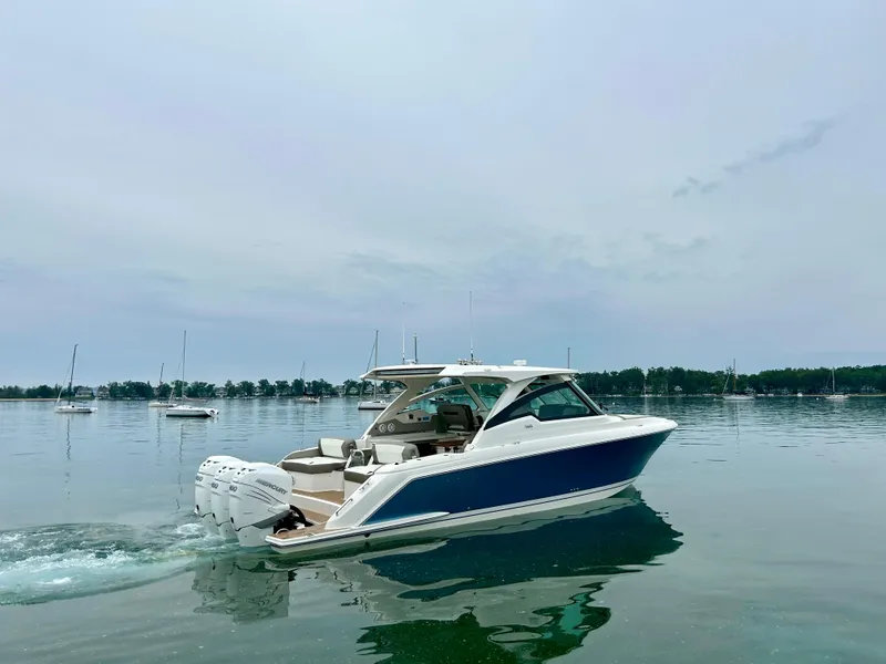 Slide: The Image of 2022 Tiara Yachts 38 LX cruising on calm waters with scenic background. - 2