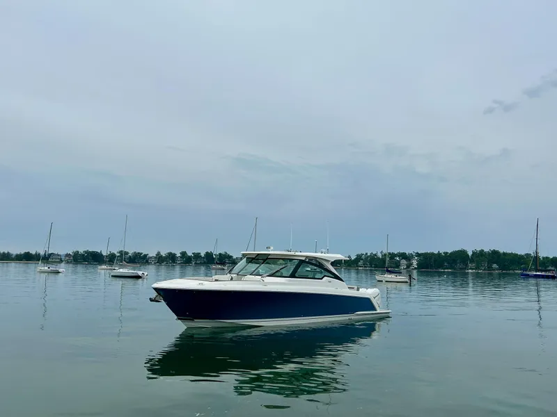 Slide: The Image of 2022 Tiara Yachts 38 LX on calm water with sailboats in the background. - 4