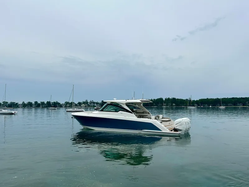 Slide: The Image of 2022 Tiara Yachts 38 LX on calm water, surrounded by sailboats. - 6