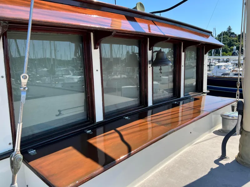 Slide: The Image of Classic 1936 Motorsailer with polished wood details and windows, docked at a marina. - 11