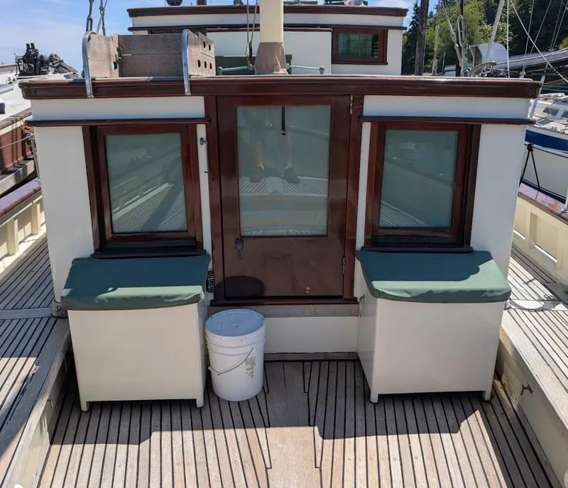 Slide: The Image of 1936 Classic Motorsailer deck with wooden cabin, green cushions, and a white bucket. - 17