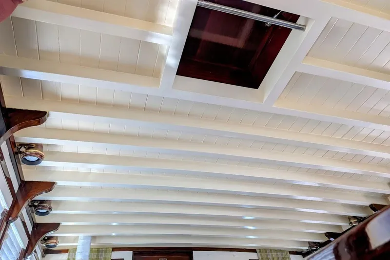 Slide: The Image of Interior ceiling of a 1936 Classic Motorsailer, showcasing wooden beams and a hatch. - 27