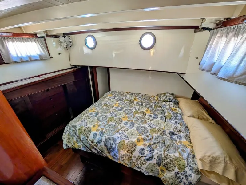 Slide: The Image of Cozy cabin interior of a 1936 Classic Motorsailer with floral bedding and wooden accents. - 29