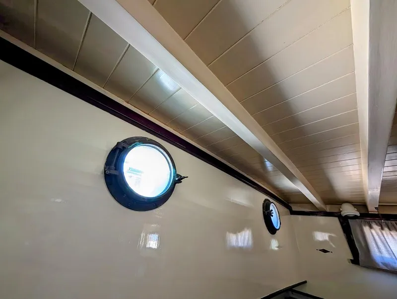 Slide: The Image of Interior of a 1936 Classic Motorsailer with portholes and wooden ceiling beams. - 31
