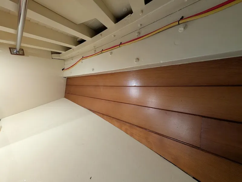 Slide: The Image of Interior view of a 1936 Classic Motorsailer, featuring wooden paneling and visible wiring. - 34