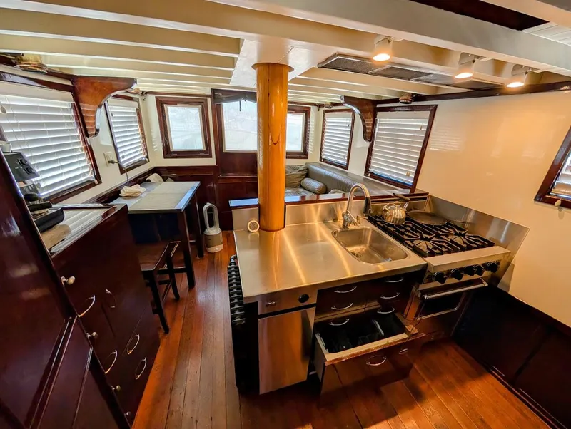Slide: The Image of Interior of a 1936 Classic Motorsailer with wooden floors, stainless steel kitchen, and cozy seating area. - 37