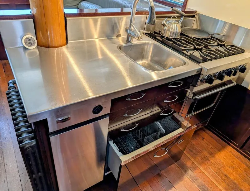 Slide: The Image of 1936 Classic Motorsailer kitchen with stainless steel sink, stove, and wooden cabinetry. - 40