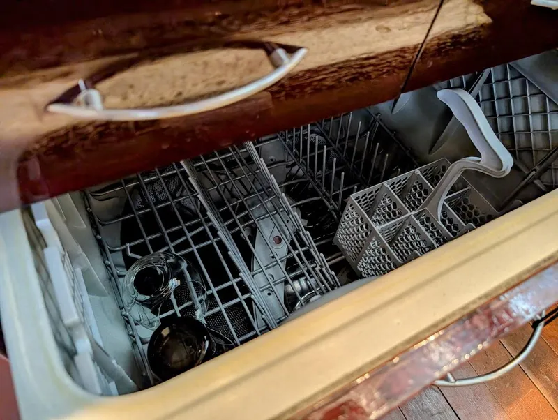 Slide: The Image of Open dishwasher drawer with empty racks and wooden cabinetry. - 41
