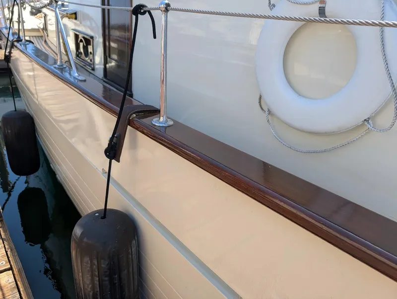 Slide: The Image of Classic 1936 Motorsailer with fenders and lifebuoy, docked at marina. - 6
