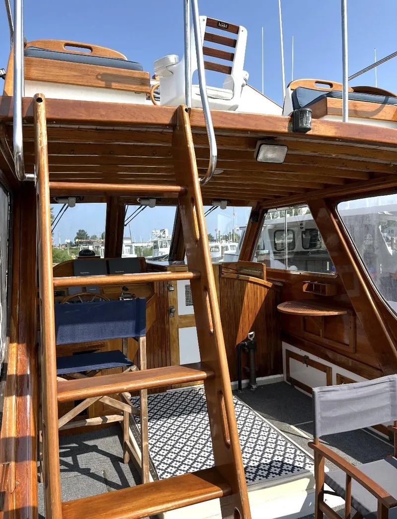 Slide: The Image of 1959 Goudy & Stevens Flybridge Cruiser with wooden interior and exterior, featuring upper deck seating. - 10