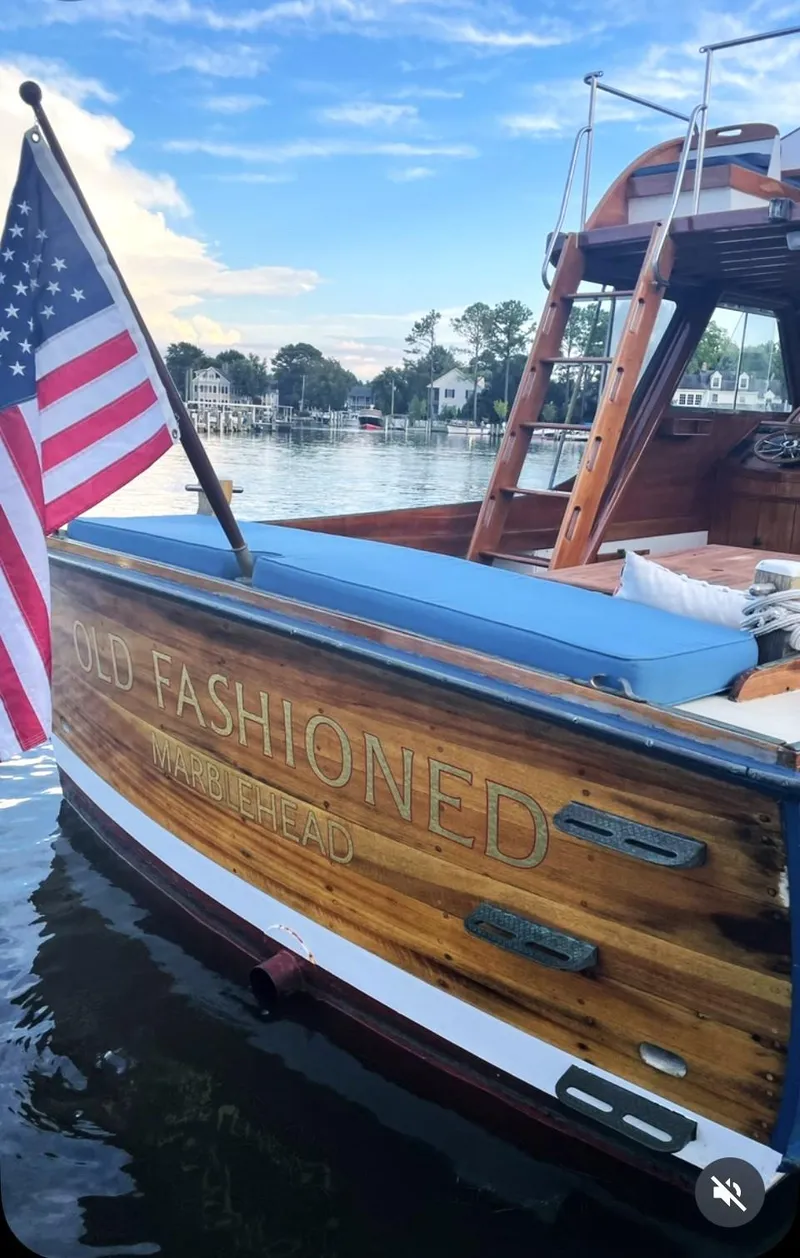 Slide: The Image of 1959 Goudy & Stevens Flybridge Cruiser with American flag on calm water. - 15