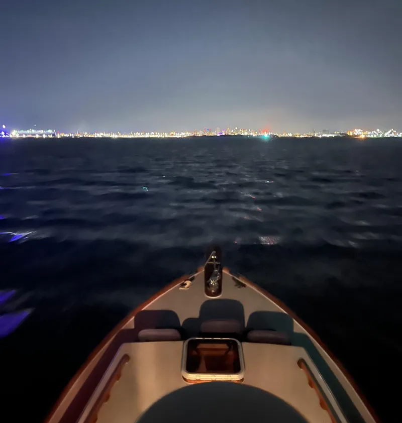 Slide: The Image of 1959 Goudy & Stevens Flybridge Cruiser on calm night waters with city lights in the distance. - 16