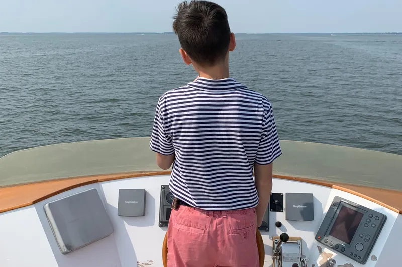 Slide: The Image of A person stands on a 1959 Goudy & Stevens Flybridge Cruiser, overlooking the ocean. - 17