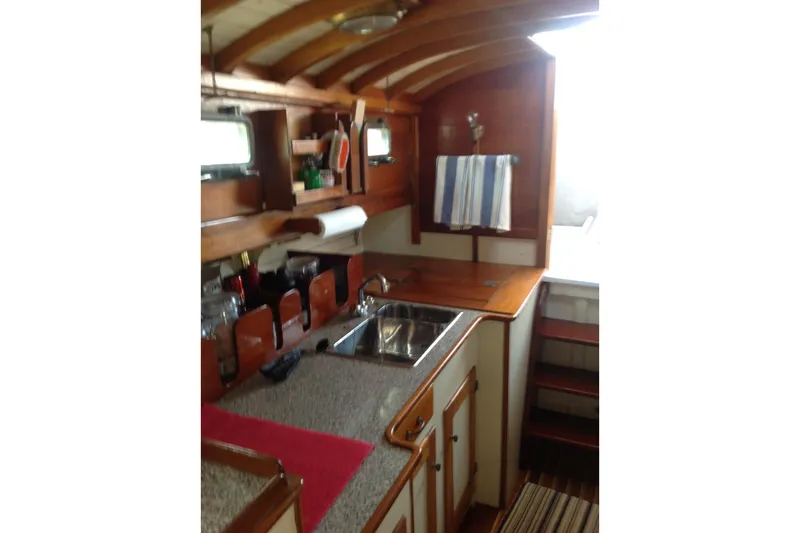 Slide: The Image of 1959 Goudy & Stevens Flybridge Cruiser kitchen with wooden cabinetry and stainless steel sink. - 21