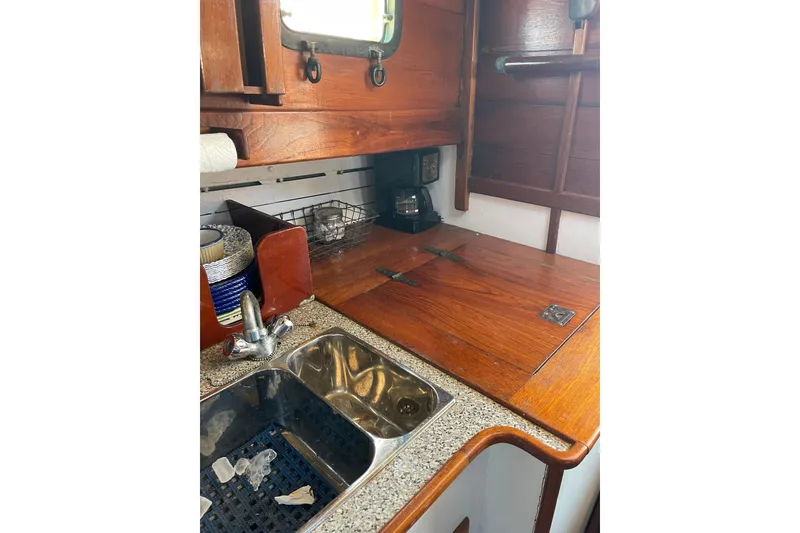 Slide: The Image of 1959 Goudy & Stevens Flybridge Cruiser kitchen with wooden cabinetry and stainless steel sink. - 22