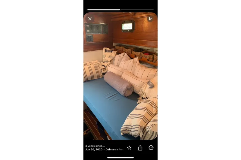 Slide: The Image of Cozy interior of 1959 Goudy & Stevens Flybridge Cruiser with striped cushions and wooden paneling. - 23