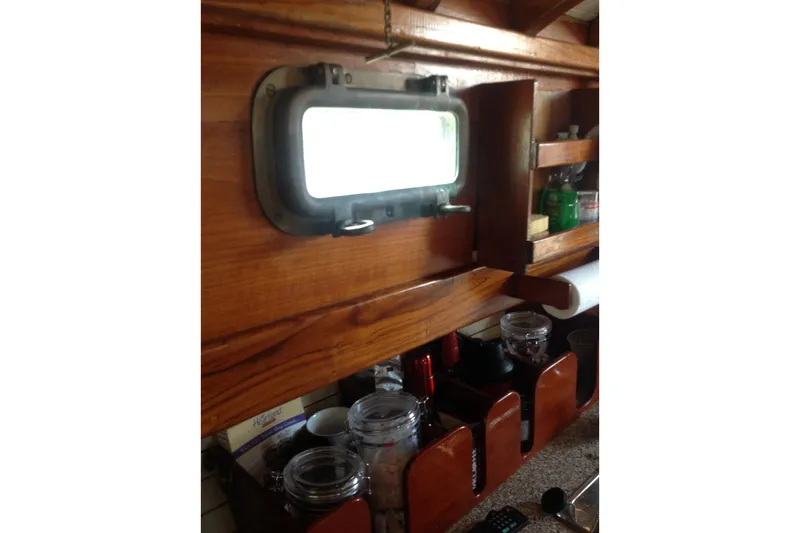 Slide: The Image of Interior of 1959 Goudy & Stevens Flybridge Cruiser with wooden shelves and porthole window. - 24