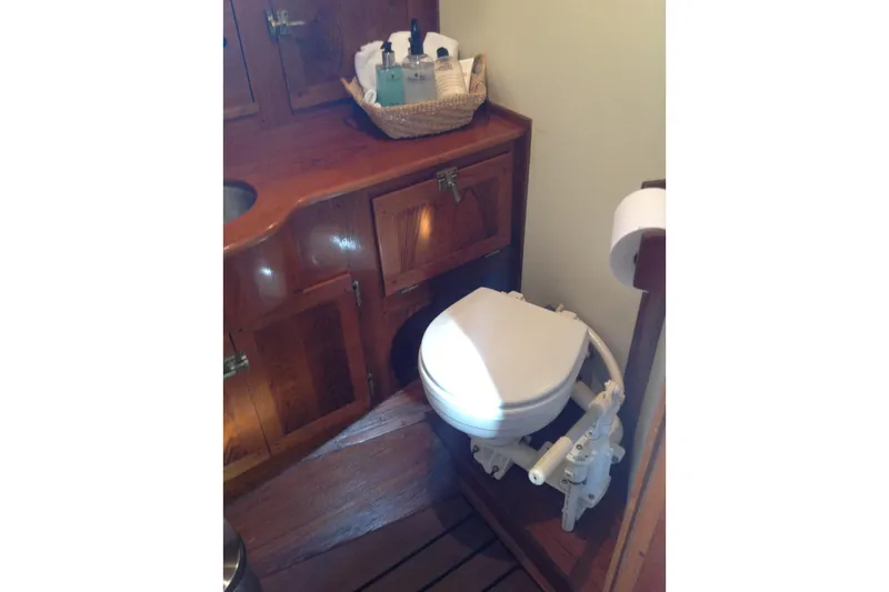 Slide: The Image of Vintage 1959 Goudy & Stevens Flybridge Cruiser bathroom with wooden cabinetry and marine toilet. - 25