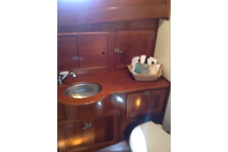 Slide: The Image of 1959 Goudy & Stevens Flybridge Cruiser bathroom with wooden cabinetry and sink. - 26