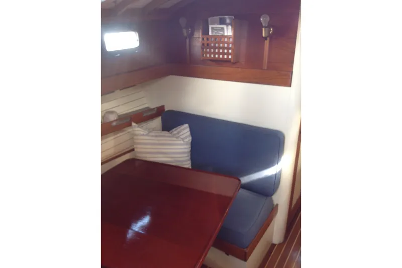 Slide: The Image of 1959 Goudy & Stevens Flybridge Cruiser interior with wooden table and blue cushioned seating. - 27
