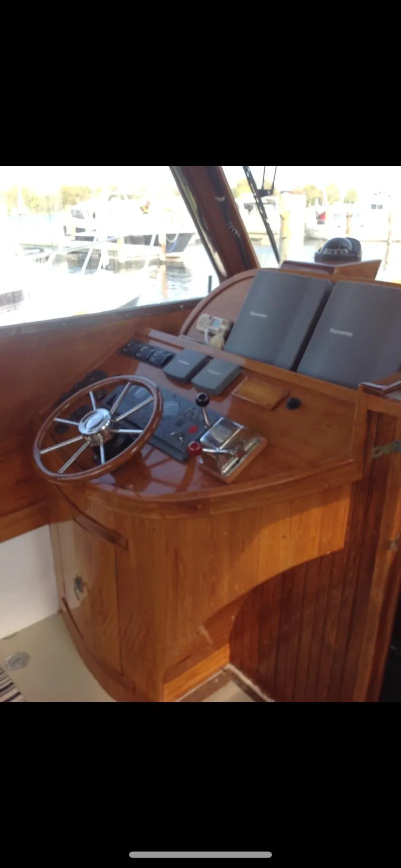 Slide: The Image of 1959 Goudy & Stevens Flybridge Cruiser helm with wooden steering wheel and navigation instruments. - 5