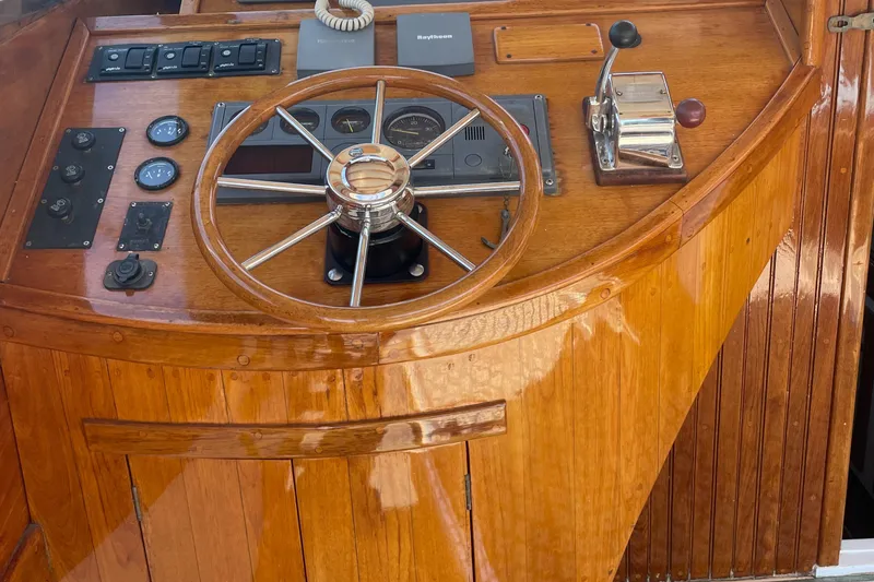 Slide: The Image of 1959 Goudy & Stevens Flybridge Cruiser helm with wooden finish and classic controls. - 6