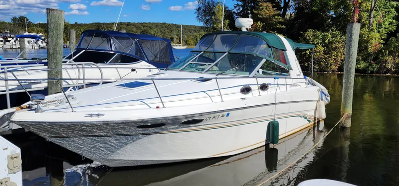 The Image of 1998 Sea Ray 290 Sundancer boat docked in a marina under a clear blue sky. - 0