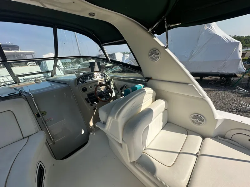 Slide: The Image of 1998 Sea Ray 290 Sundancer boat interior with steering wheel and seating area. - 10