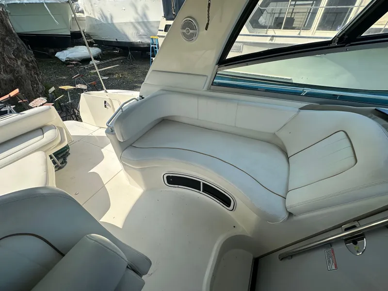 Slide: The Image of 1998 Sea Ray 290 Sundancer boat interior with white seating and window view. - 11