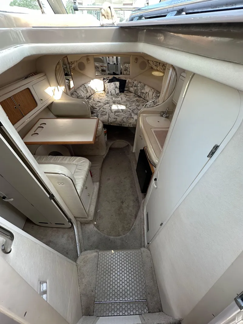 Slide: The Image of 1998 Sea Ray 290 Sundancer cabin interior with seating, table, and kitchenette. - 16