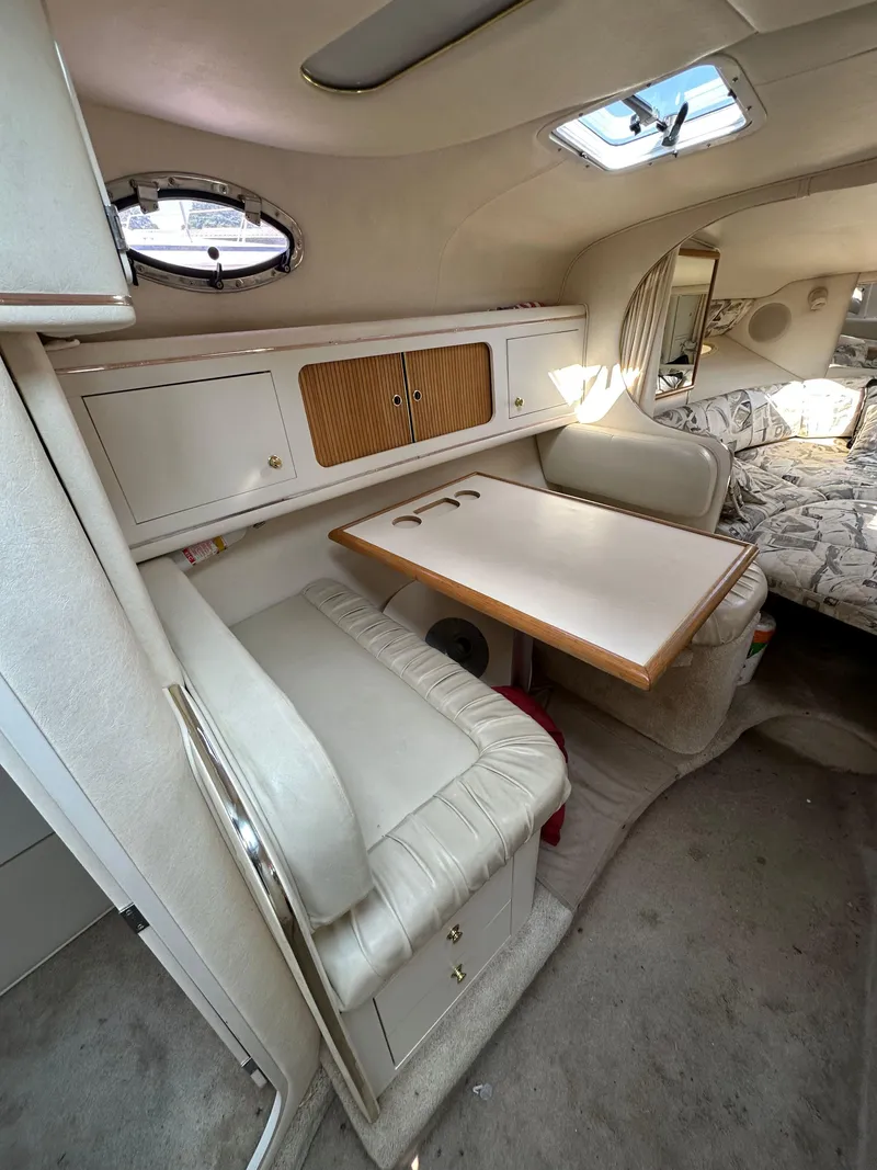 Slide: The Image of 1998 Sea Ray 290 Sundancer cabin interior with dining area and bed. - 17