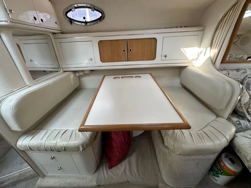 Slide: The Image of 1998 Sea Ray 290 Sundancer cabin interior with dining area and storage cabinets. - 18
