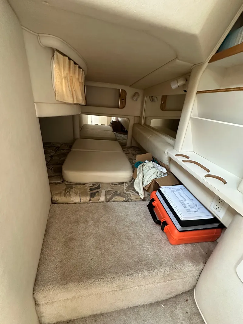 Slide: The Image of 1998 Sea Ray 290 Sundancer cabin interior with beds and storage shelves. - 23