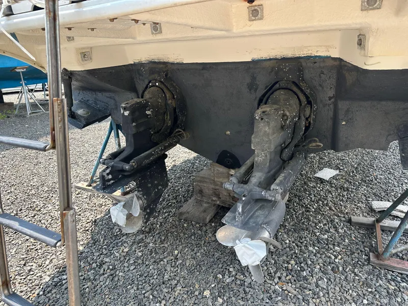 Slide: The Image of 1998 Sea Ray 290 Sundancer boat stern with dual outdrives on gravel surface. - 26