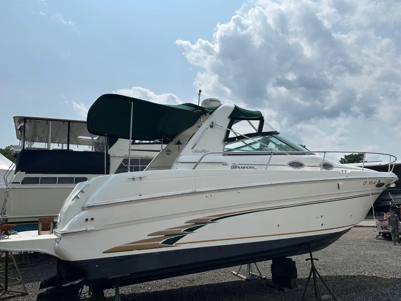 Slide: The Image of 1998 Sea Ray 290 Sundancer boat on dry dock under cloudy sky. - 6