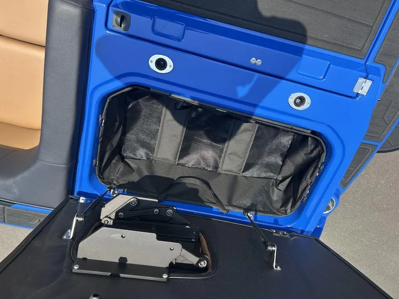 Slide: The Image of 2025 Moomba Tykon interior storage compartment with blue and black detailing. - 11