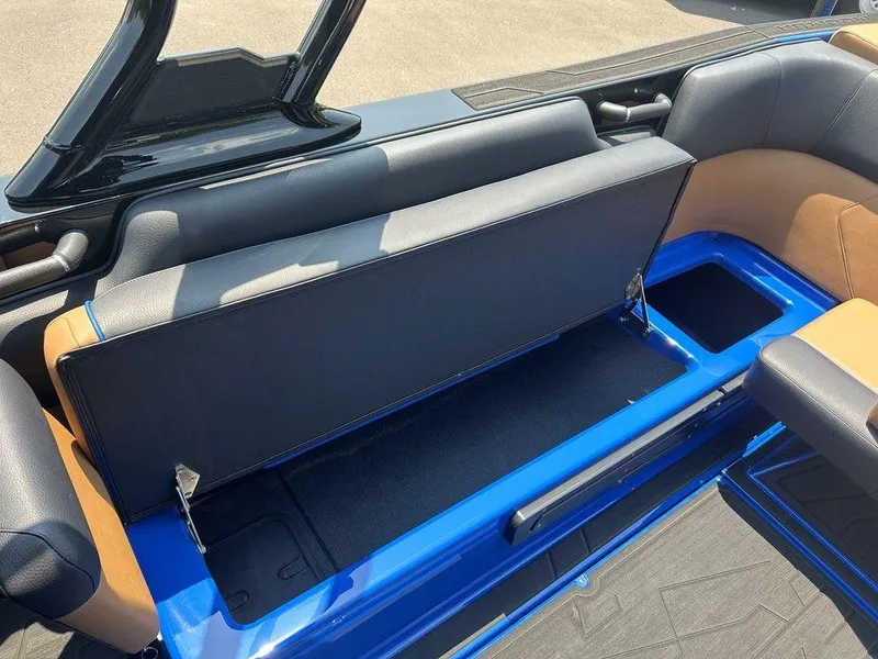 Slide: The Image of 2025 Moomba Tykon boat interior with open storage compartment, featuring blue and tan seating. - 15