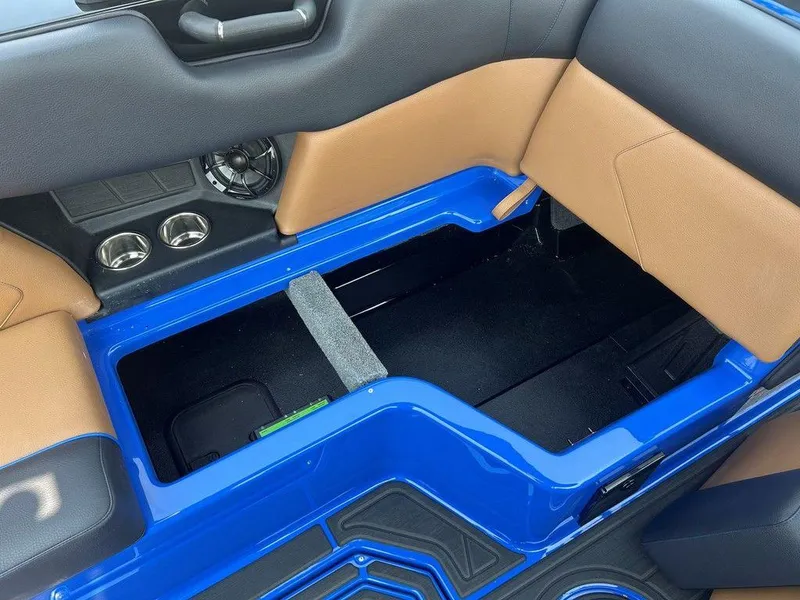 Slide: The Image of 2025 Moomba Tykon interior storage compartment with blue and tan accents. - 18
