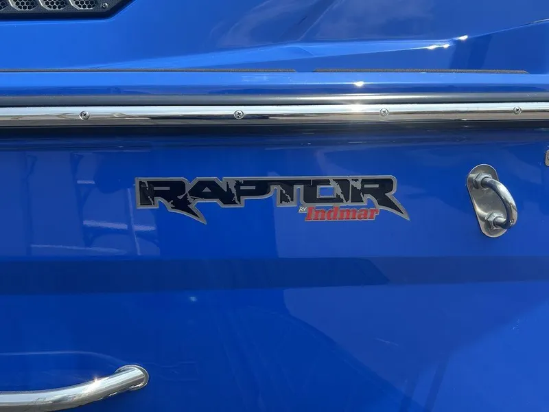 Slide: The Image of 2025 Moomba Tykon boat with Raptor by Indmar logo on blue exterior. - 2