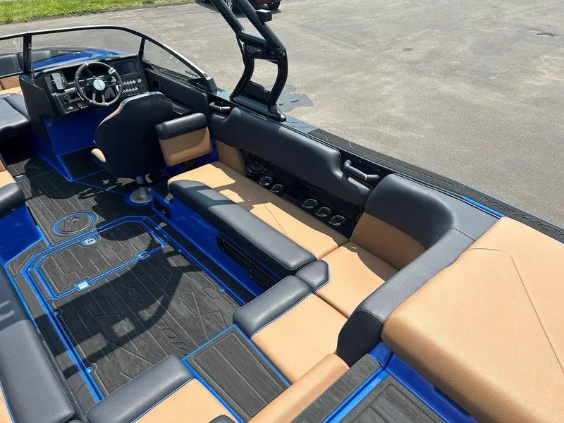 Slide: The Image of 2025 Moomba Tykon boat interior with tan and black seating, blue accents, and modern dashboard. - 27