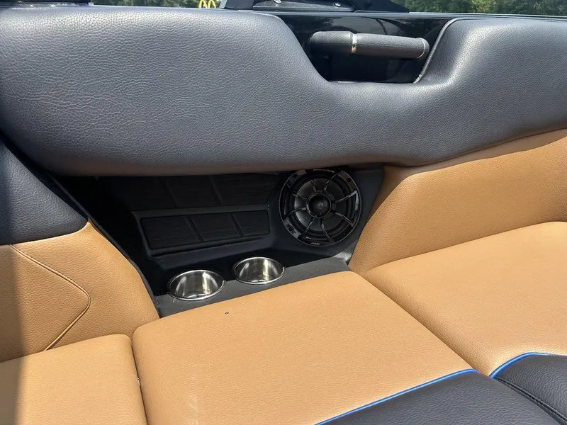 Slide: The Image of 2025 Moomba Tykon interior with tan and black seating, cup holders, and speaker. - 30