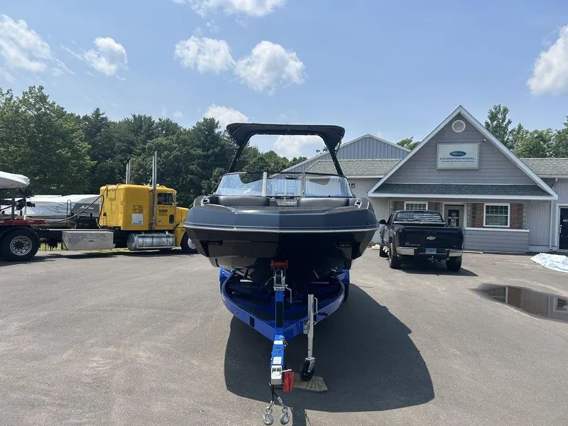 Slide: The Image of 2025 Moomba Tykon boat on trailer, parked outside dealership under clear sky. - 34