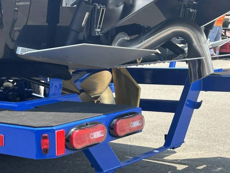 Slide: The Image of 2025 Moomba Tykon boat trailer with propeller and exhaust detail, featuring blue frame and red lights. - 7