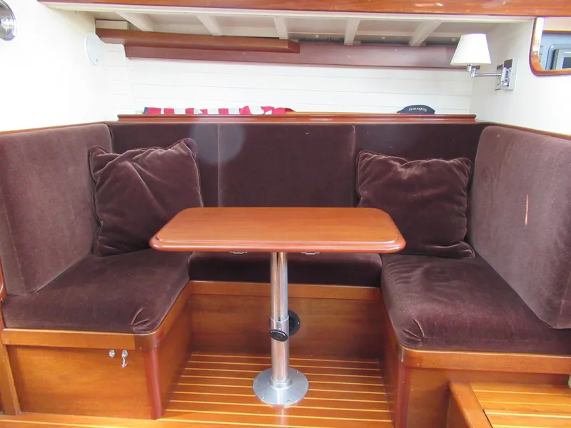 Slide: The Image of Cozy 1970 Sparkman and Stephens yacht interior with plush seating and wooden table. - 10