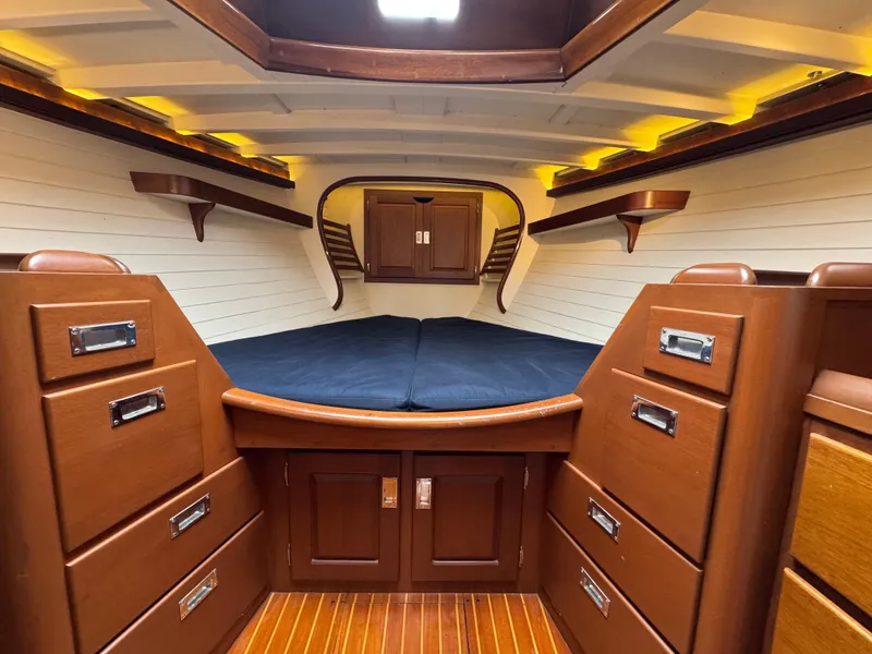 Slide: The Image of Luxurious 1970 Sparkman and Stephens yacht interior with wooden cabinetry and cozy sleeping area. - 13